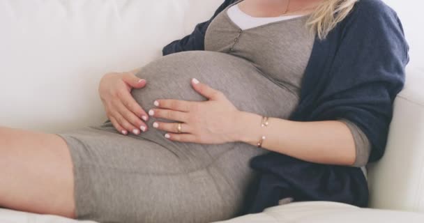 Woman, pregnant and couch with touching belly for love, peace and connection with baby to bond. Future parent, maternity leave and family home with prenatal care for relax, happiness and motherhood. - Footage, Video