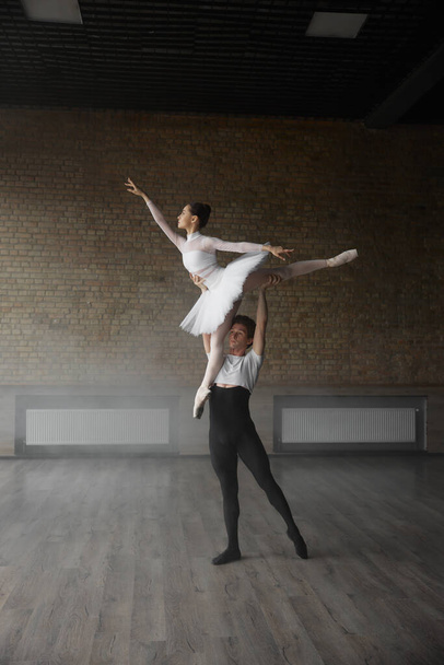 Két fiatal balett táncos jelmezben gyakorol együtt a stúdió órán. Színházi előadás próba foglalkozás - Fotó, kép