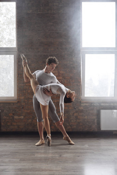 Contemporânea bailarinos casal realizando coreografia graciosa na aula de arte da escola - Foto, Imagem