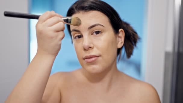 Fiatal gyönyörű spanyol nő alkalmazása smink a fürdőszobában - Felvétel, videó