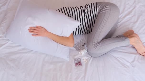 Τρομαγμένη καταθλιπτική γυναίκα ξαπλωμένη μόνη στο κρεβάτι σε εμβρυακή στάση, σκεπασμένη με μαξιλάρι. Πάσχει από αϋπνία, στομαχόπονο ψυχικά προβλήματα. - Πλάνα, βίντεο