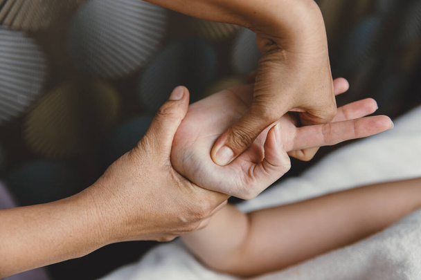 Proces masażu dłoni. Nadgarstek ścięgna rozciąganie i akupresura dla relaksu i uzdrowienia w spa dla azjatyckiej kobiety opieki zdrowotnej - Zdjęcie, obraz