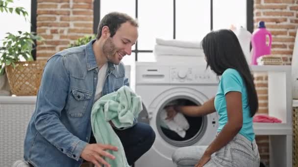 Красива пара посміхається впевнено прати одяг високої п'ятірки в пральні - Кадри, відео