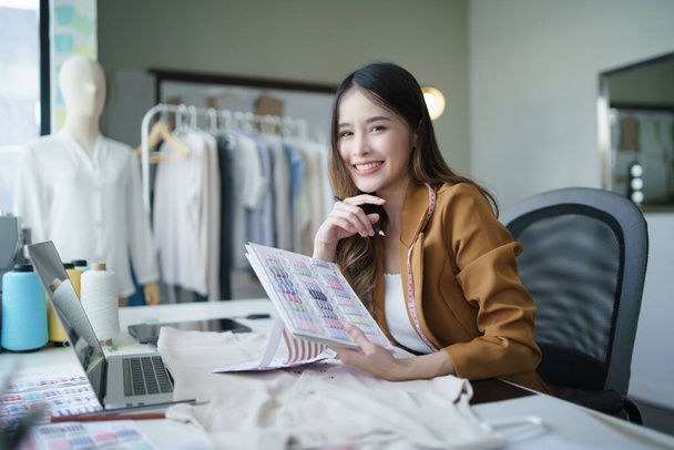 Mujer joven asiática optimista hizo su pequeño negocio como diseñador de ropa. Estilo de vida nueva generación empresaria freelancer. - Foto, Imagen