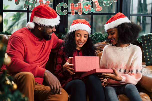 Afrikanische Familie freut sich über Geschenkbox in der Weihnachtszeit. - Foto, Bild