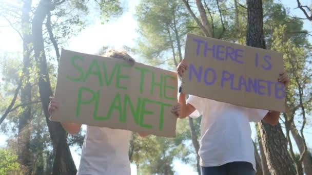 niños voluntarios con el cartel de Save the planet. niño activista infantil sin pancarta de plástico en el parque forestal. jóvenes luchan contra el Calentamiento Global, reciclan residuos de basura. Ecología problema ambiental - Imágenes, Vídeo