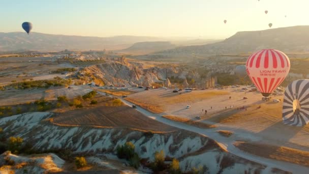 Goreme, Turkije 5 augustus 2023: Kleurrijke ballonnen vliegen over een vallei van magische schoorstenen in Nevsehir, Goreme, Cappadocië, Turkije. Adembenemend panoramisch uitzicht vanaf drone - Video