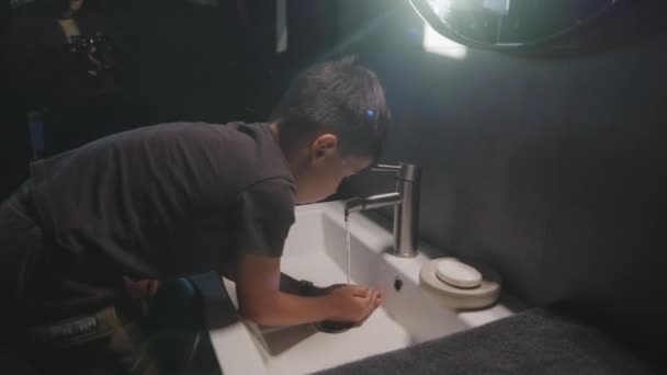 Šťastný chlapec si hraje s vodou tekoucí z kohoutku a baví se při mytí rukou ve vaně. Význam dobrých hygienických návyků pro děti. - Záběry, video