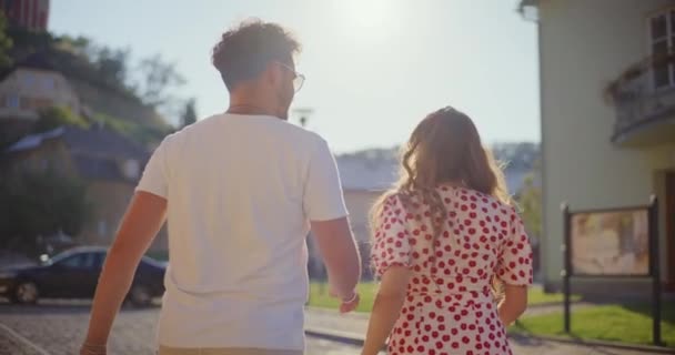 Allegra donna bionda che parla con il fidanzato mentre cammina nella giornata di sole durante il fine settimana - Filmati, video