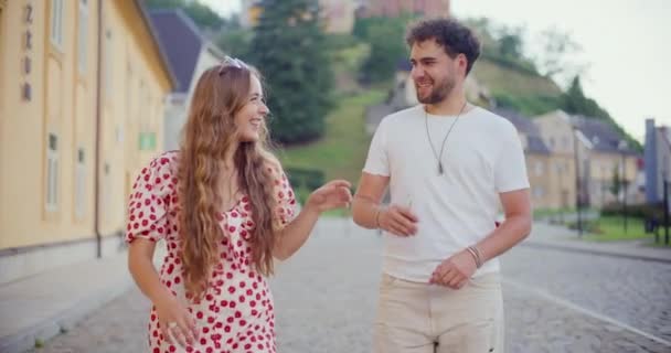 Bionda giovane donna che ride e parla con il fidanzato mentre cammina sul sentiero - Filmati, video