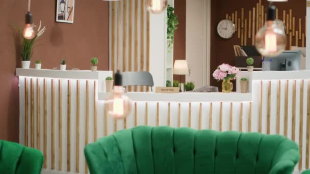 Leere tropische Hotellounge mit luxuriöser Couch und moderner Rezeption, stilvolles Interieur. Empfangshalle mit Uhren und kühlem Licht, luxuriöser Raum mit Pflanzen. - Filmmaterial, Video