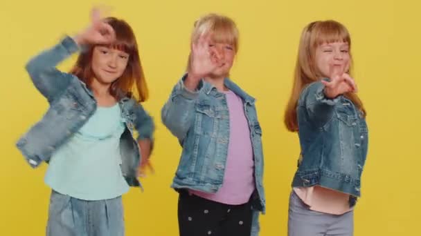 Okay. Teenage girls. Little children sisters looking approvingly at camera showing ok gesture, like sign positive, approve something good. Three siblings kids isolated on studio yellow background - Footage, Video