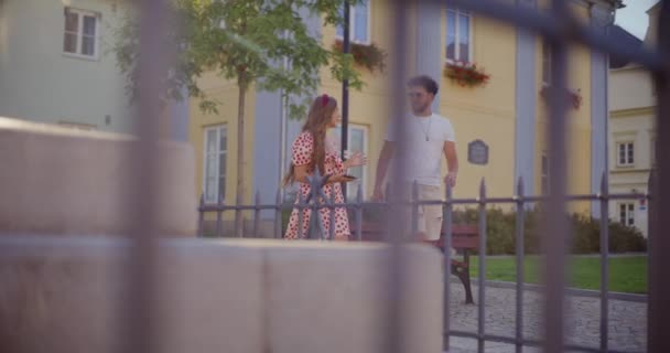 Femme blonde avec téléphone intelligent parlant à son petit ami tout en marchant dans le jardin pendant le week-end - Séquence, vidéo