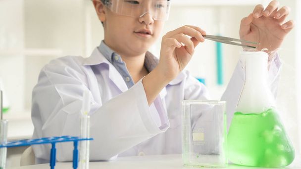 子供科学者は,実験室で生物学と化学について学びます. STEM教育学習コンセプト。 STEMクラスの研究室で化学ビーカーで勉強しているアジアの学生の少年. - 写真・画像