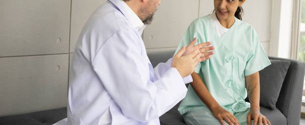 Blanke mannelijke arts diagnose voor wortel oorzaak vinden met Spaanse vrouwelijke patiënt. Knieblessure probleem. Het medisch onderzoek en de check-up met het doktersconcept. - Foto, afbeelding