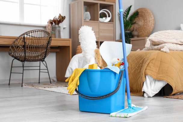 Bucket with cleaning supplies in bedroom - Photo, Image