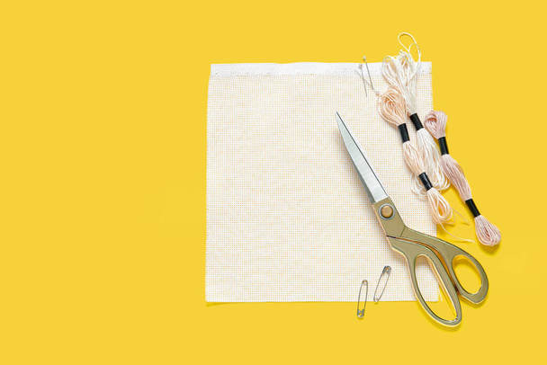 Kangas sakset, mouline kierteet ja nastat keltaisella taustalla - Valokuva, kuva