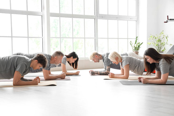 Group of sporty people doing plank in gym - Photo, Image