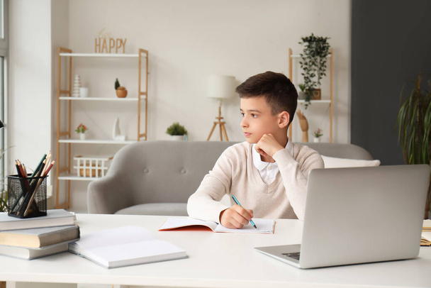 Kleine jongen studeren online met laptop thuis - Foto, afbeelding