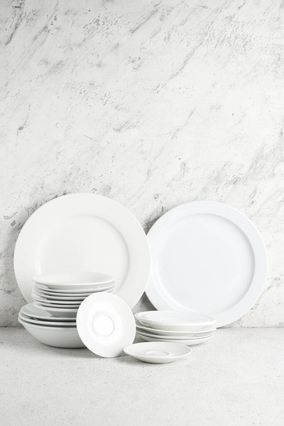 Zestaw czystych talerzy i talerzy na białym stole - Zdjęcie, obraz