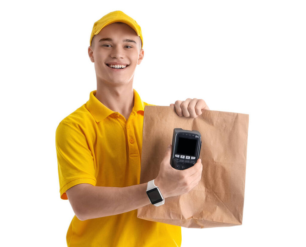 Young courier with paper bag and payment terminal on white background - Photo, Image