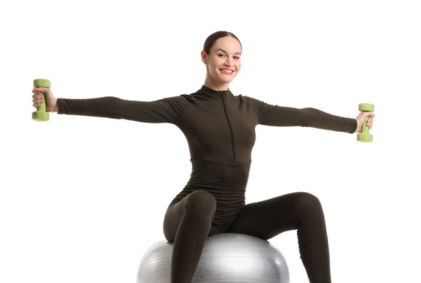 Sporty young woman with dumbbells and fitball on white background - Photo, Image
