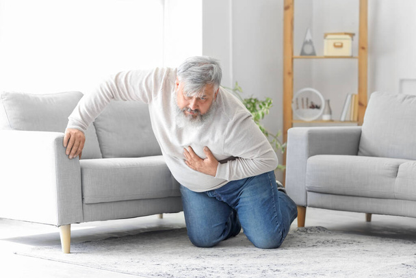 Elderly man having heart attack at home - Photo, Image