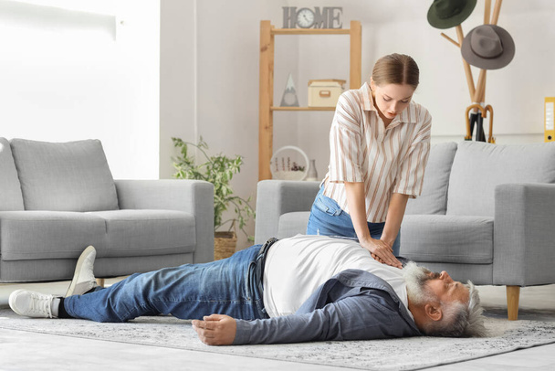 Mulher fazendo RCP em seu pai inconsciente em casa - Foto, Imagem