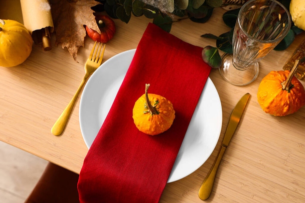 Ajuste de mesa festivo con calabazas y cubiertos de oro para la fiesta de Halloween, primer plano - Foto, imagen