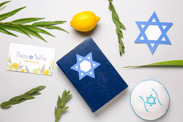 Composición del festival Sukkot con cuatro especies (lulav, hadas, arava, etrog), Torá y tarjeta de felicitación sobre fondo gris - Foto, Imagen