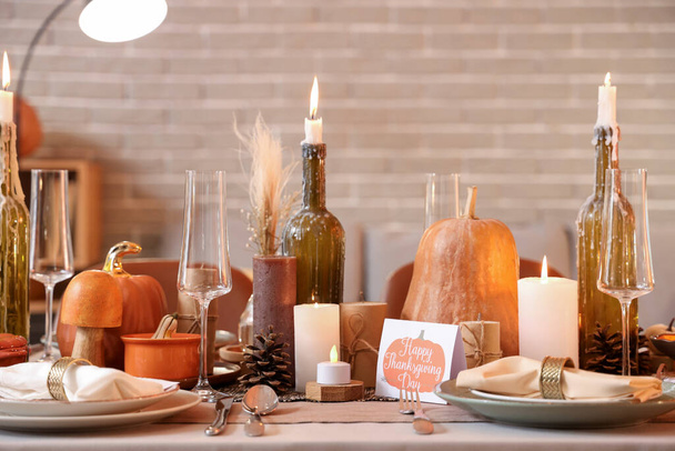 夕方に感謝祭の夕食のためのろうそく,カボチャおよび挨拶カードを燃やすことの美しいテーブルの設定 - 写真・画像