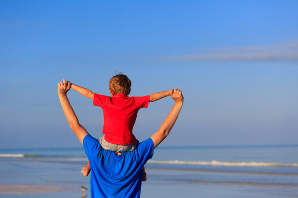 onnellinen isä ja poika leikkivät meren rannalla
 - Valokuva, kuva
