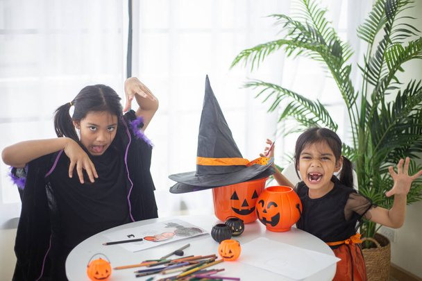 Glückliches asiatisches Kindermädchen im Hexenkostüm zu Halloween. Süßes oder Saures. Kinder tricksen oder behandeln. - Foto, Bild