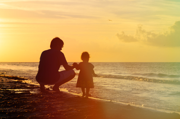 Ο πατέρας και η μικρή κόρη σιλουέτες στο ηλιοβασίλεμα - Φωτογραφία, εικόνα
