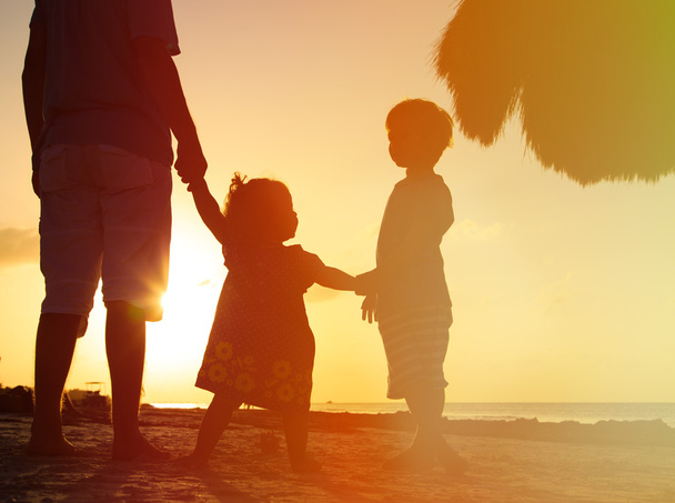 pai e dois filhos caminhando ao pôr do sol
 - Foto, Imagem