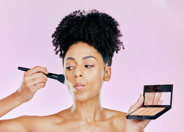 Makeup brush, palette and studio face of woman with tools, beauty routine and apply cosmetics powder, foundation or product. Mirror, facial transformation process and salon person on pink background. - Фото, зображення
