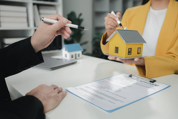 Pracownicy działu sprzedaży omawiają szczegóły dotyczące domu z klientami przed wyrażeniem zgody na podpisanie umowy sprzedaży, kupno i sprzedaż nieruchomości, składanie rekomendacji i ofert, sporządzanie umów sprzedaży domów. - Zdjęcie, obraz