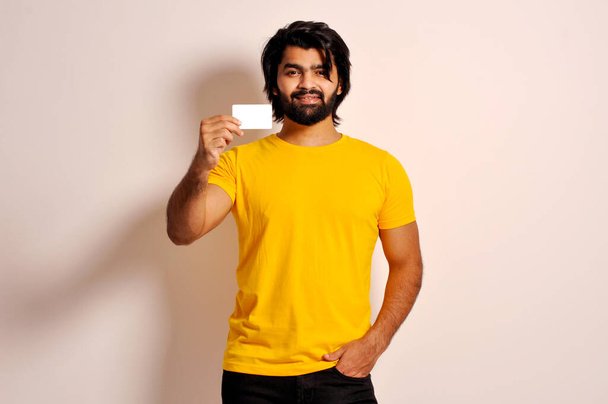 Portret van positieve Indiase man houden credit card suggereren gemakkelijk bancaire winst betaalpunt index vinger  - Foto, afbeelding