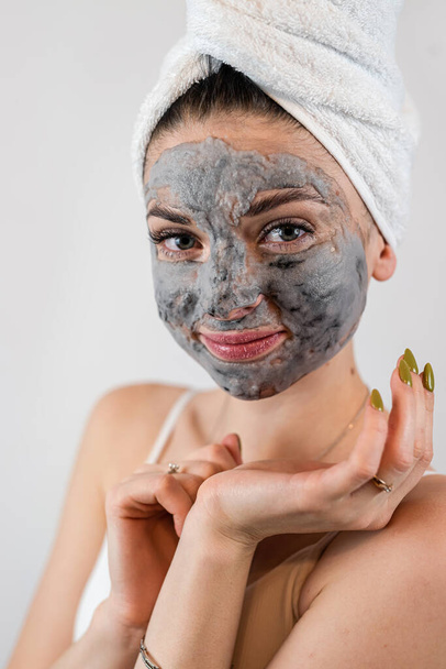 ziemlich sexy Frau Anwendung Ton schwarze Maske auf weißem Hintergrund. Hautpflege, Wellness-Behandlungen für perfekte Haut - Foto, Bild