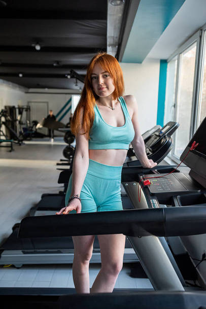 mladá sportovní žena stojí u závodiště v tělocvičně. Cvičení sportovní koncept. Zdravý životní styl - Fotografie, Obrázek