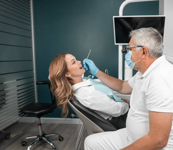 Pacjent otrzymuje indywidualne porady dotyczące stanu zębów i możliwych zabiegów medycznych. Implanty stomatologiczne są instalowane w centrum medycznym w celu przywrócenia funkcjonalności jamy ustnej - Zdjęcie, obraz