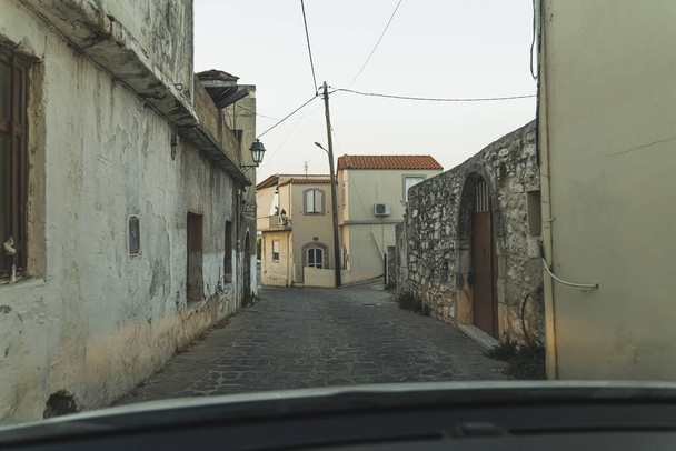 Après-midi calme dans une petite rue traditionnelle du village grec de Crète, en Grèce. Allée étroite typique dans la jolie ville antique. Photo de haute qualité - Photo, image