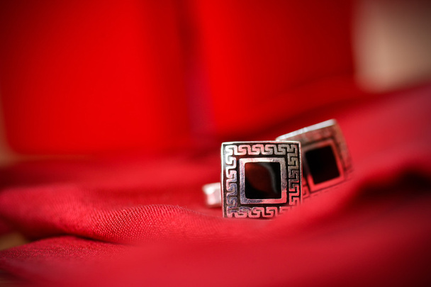 Black cufflinks for shirt in a nice red background - Photo, Image