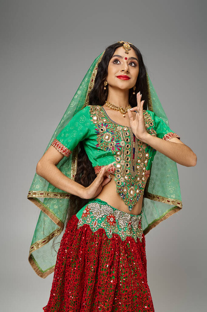 vertikale Aufnahme einer schönen langhaarigen Indianerin mit Bindi Dot, die gestikuliert und wegschaut - Foto, Bild