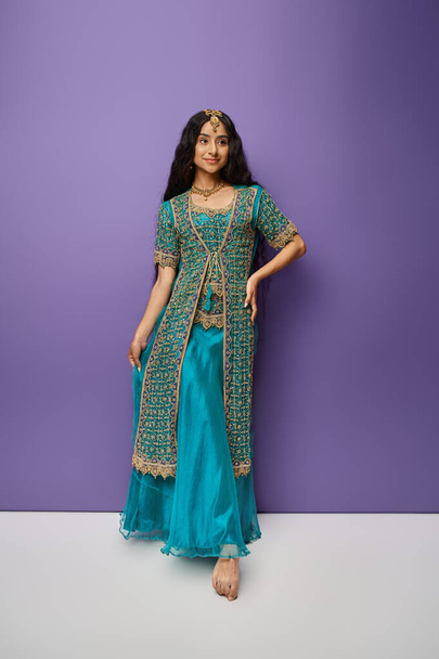 美しいインドの女性の垂直ショット 伝統的な服で喜んで笑って離れて見て - 写真・画像