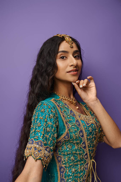 紫色の背景にポーズし,カメラを見ている伝統的なブルーサリーの美しいインドの女性 - 写真・画像