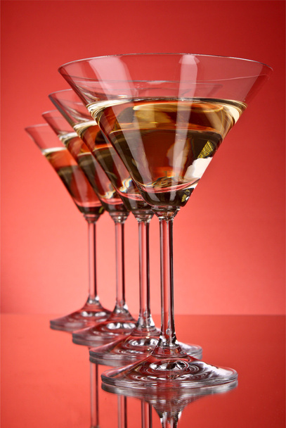 A few glasses of martini on a red background - Foto, Imagem