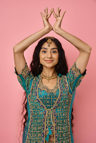 κάθετη λήψη της όμορφης Ινδής με το παραδοσιακό μπλε σάρι να κάνει χειρονομίες χορεύοντας ζωηρά - Φωτογραφία, εικόνα