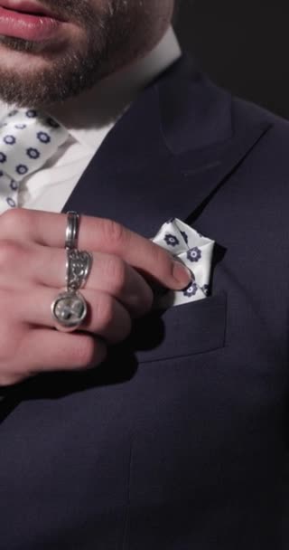Nahaufnahme-Video eines Geschäftsmannes der gehobenen Klasse, der das passende Taschentuch anpasst, sinnlich ist und die Lippen berührt, während er vor grauem Hintergrund zur Seite schaut - Filmmaterial, Video