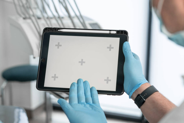 歯科医院歯科医の電子タブレットを追跡するためのクロマキーエフェクトグリーンスクリーンは,手を示し,予約と相談で歯科椅子の患者に画面に表示します. 高品質で - 写真・画像